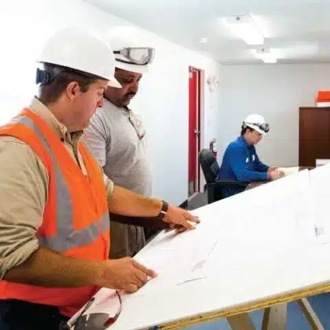 Workers reviewing plans at a SiteBox planning table