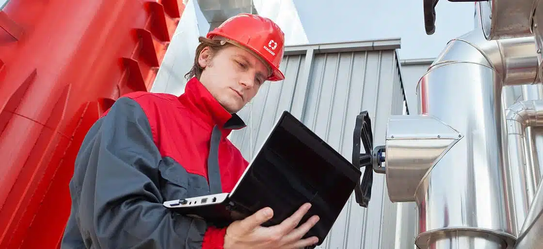 Engineer in a red hard hat reviewing documents